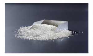 Diamants bruts blancs en vrac boîte carton fond gris